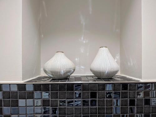 two vases sitting on top of a tile shelf at The Old Fire Station Luxury Apartment in York