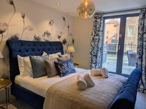 a bedroom with a large bed with a blue headboard at The Old Fire Station Luxury Apartment in York