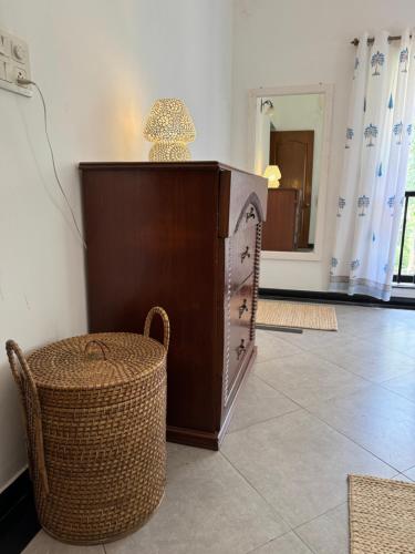 a podium with a clock and a wicker chair at Cim and Sands in Goa