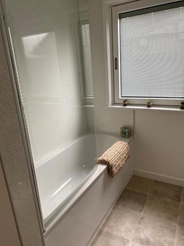 a bathroom with a white tub and a window at Wheal Rock - Luxury 2 Bed Lodge in St. Agnes