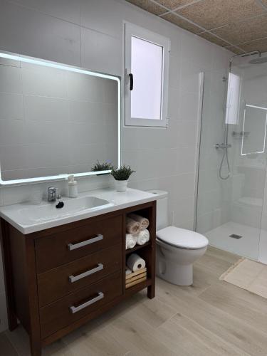 a bathroom with a sink and a toilet and a mirror at Apartamentos Murcia río in Murcia
