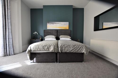 a bedroom with a bed with a black headboard at Dwell Living Argyle Square in Sunderland