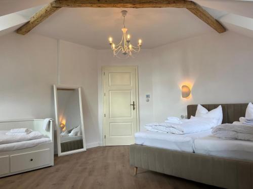 ein Schlafzimmer mit zwei Betten und einem Spiegel und einem Kronleuchter in der Unterkunft Residence Polonia - LAST available dates in Karlsbad