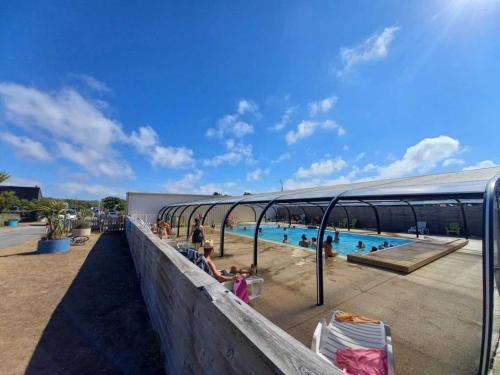 - une piscine dans un complexe avec des personnes dans l'eau dans l'établissement Camping 3 étoiles - Piscine - eehghh, à Ploemeur