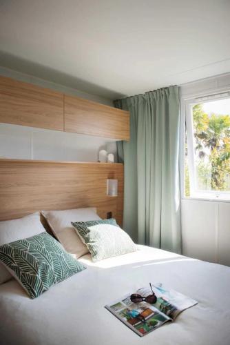 - une chambre avec un lit et un magazine dans l'établissement Camping 3 étoiles - Piscine - eehghh, à Ploemeur