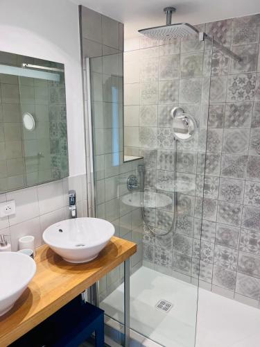 une salle de bain avec deux lavabos et une douche dans l'établissement Le photographe- Appt de standing entre gare et lac, à Annecy
