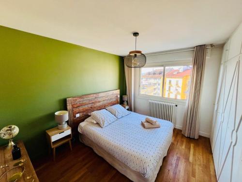 une chambre avec un lit et un mur végétal dans l'établissement Le photographe- Appt de standing entre gare et lac, à Annecy