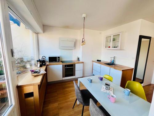 une cuisine avec une table et des chaises dans une pièce dans l'établissement Le photographe- Appt de standing entre gare et lac, à Annecy