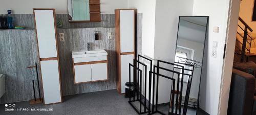 a bathroom with a sink and a mirror at Monteur-Ferienwohnung mit 123qm bei Würzburg mit Parkplatz Terasse Grill WLAN in Veitshöchheim