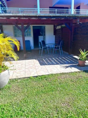 a patio with chairs and a table in a house at Appartement confortable à Lamentin 60 m² avec jardin in Lamentin