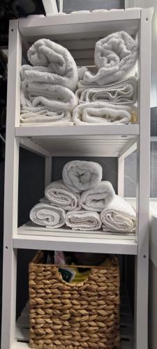 a closet filled with white towels and a basket at 2 bedrooms and 1 living room Your modern home in Budapest in Budapest