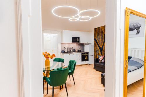 a dining room with a table and green chairs at 2 bedrooms and 1 living room Your modern home in Budapest in Budapest