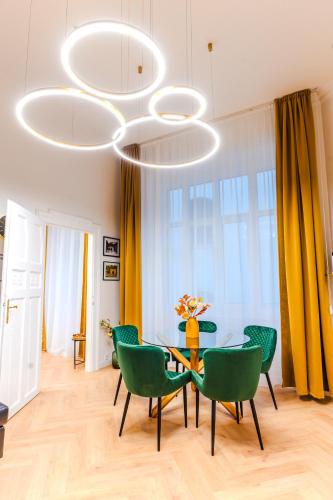 a dining room with a table and green chairs at 2 bedrooms and 1 living room Your modern home in Budapest in Budapest
