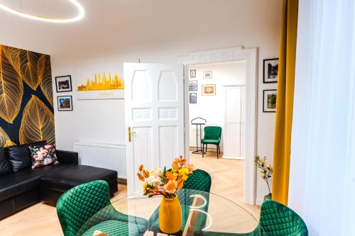 a living room with a glass table and green chairs at 2 bedrooms and 1 living room Your modern home in Budapest in Budapest