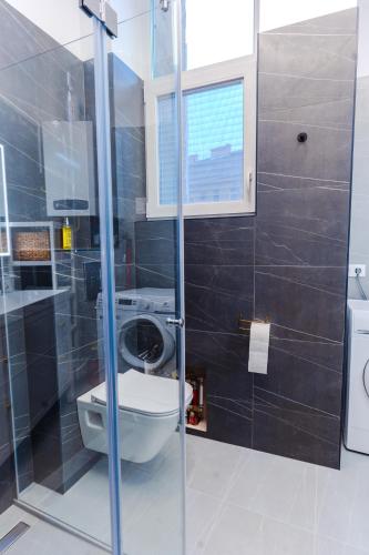 a bathroom with a toilet and a glass shower at 2 bedrooms and 1 living room Your modern home in Budapest in Budapest