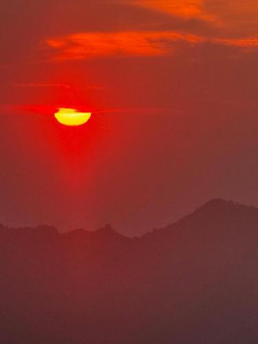 a red sunset with mountains in the background at Miterio Mundo Nuevo in Minca
