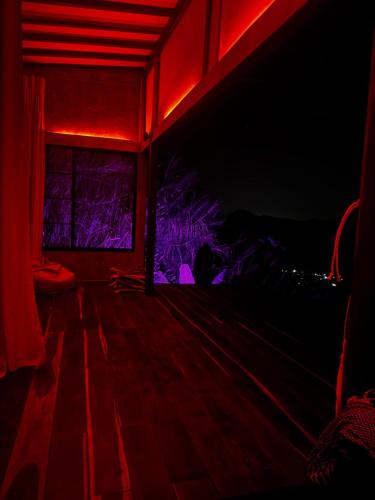 a red room with a window and a wooden floor at Miterio Mundo Nuevo in Minca