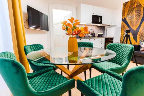 a dining room with a glass table and green chairs at 2 bedrooms and 1 living room Your modern home in Budapest in Budapest