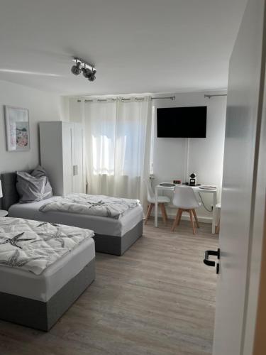 a room with two beds and a table and a television at Schloss Appartement in Paderborn