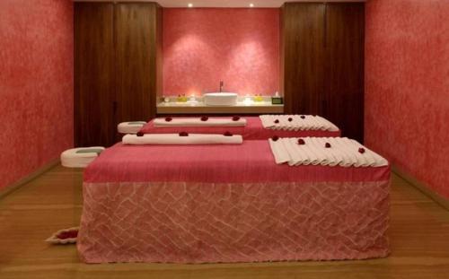 a room with three beds with red walls at The Park Kolkata in Kolkata