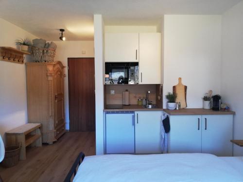 a room with a kitchen and a bed in a room at Ferienwohnung Gipfelstürmer in Schleching