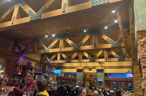 a crowd of people in a bar with a large wooden wall at Modern Riverstone Condo with Grand Deck - Steps to Shops, Restaurants, Trails and River in Coeur d'Alene
