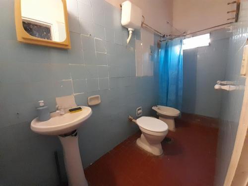 a bathroom with a sink and a toilet and a window at Quintana in Asunción