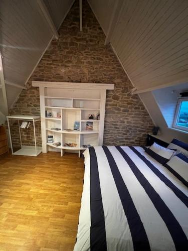 a bedroom with a bed and a brick wall at Le Bleu d 'Audinghen in Audinghen