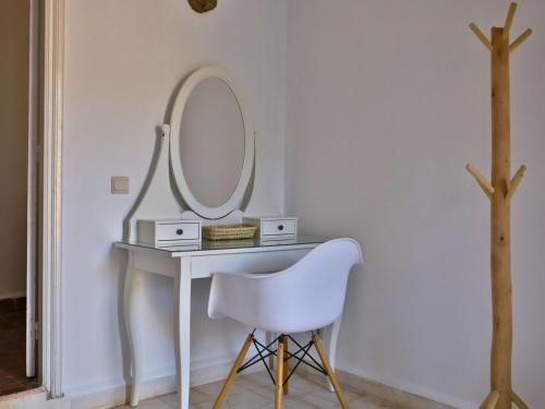a dressing table with a white chair and a mirror at L'Hacienda Joud - Privatisation de 5 chambres dans un havre de paix à Marrakech avec piscine & cuisinière privée dans le désert d'Aït Ourir in Aïn er Rmel