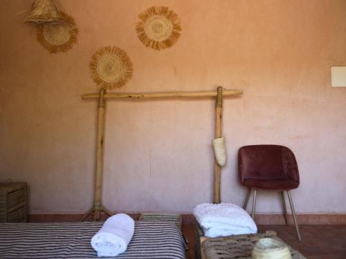 a bedroom with two beds and a chair in it at L'Hacienda Joud - Privatisation de 5 chambres dans un havre de paix à Marrakech avec piscine & cuisinière privée dans le désert d'Aït Ourir in Aïn er Rmel