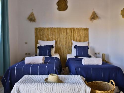 two beds in a room with blue and white at L'Hacienda Joud - Privatisation de 5 chambres dans un havre de paix à Marrakech avec piscine & cuisinière privée dans le désert d'Aït Ourir in Aïn er Rmel