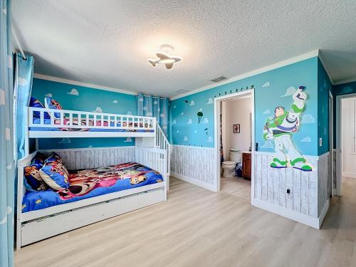 a childs bedroom with blue walls and a bunk bed at Tranquility Hut, Spacious 4-bedrooms, 4-bathrooms, Pools, free parking in Kissimmee