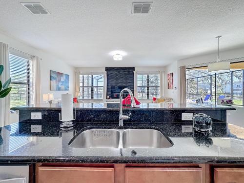a kitchen with a sink and a counter top at Tranquility Hut, Spacious 4-bedrooms, 4-bathrooms, Pools, free parking in Kissimmee