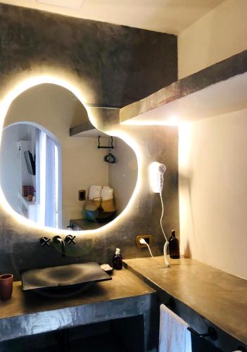a bathroom with a sink and a circular mirror at WAYTAY in Cafayate