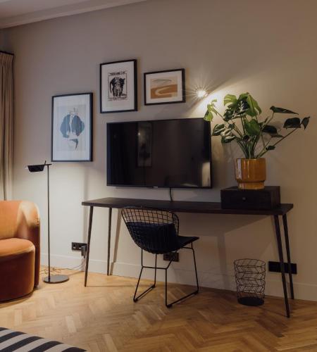 a room with a desk with a television and a chair at Suite no 7, hidden gem center of Amsterdam in Amsterdam