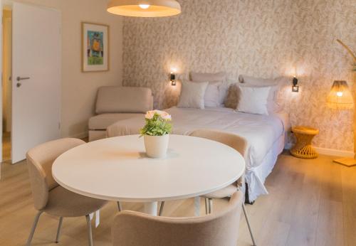 a bedroom with a bed and a table and chairs at Le Gabriel in Strasbourg