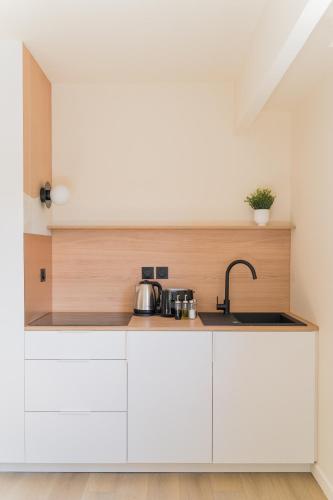 une cuisine avec des armoires blanches et un évier dans l'établissement Le Gabriel, à Strasbourg