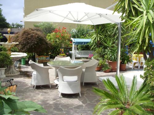 a patio with a table and chairs and an umbrella at Hotel Cristina in Chianciano Terme