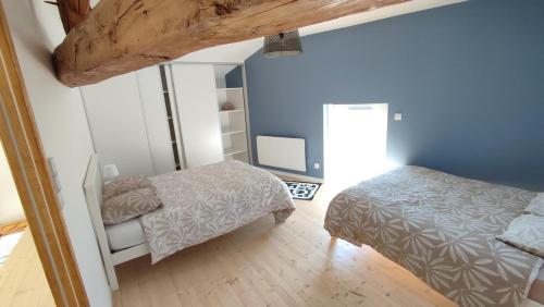 ein Schlafzimmer mit zwei Betten und einem Spiegel in der Unterkunft La tanière des trois Ogres, à 10min du Futuroscope in Beaumont