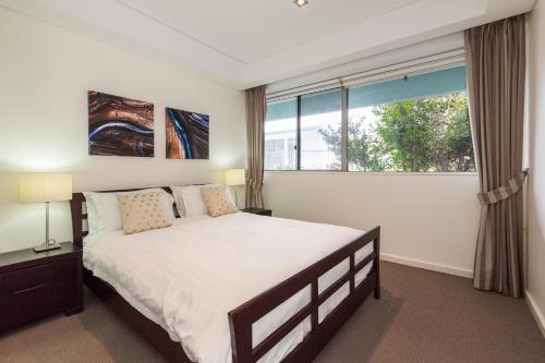 弗里曼特的住宿－畫廊服務公寓，一间卧室设有一张大床和一个窗户。