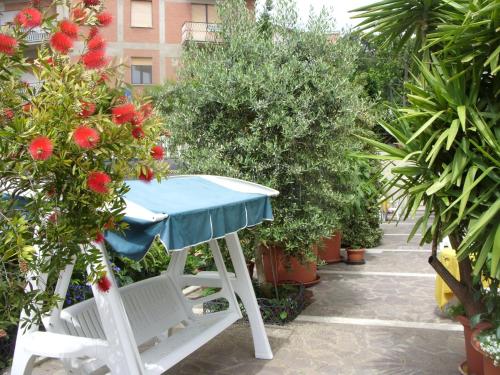 a table and chair in a garden with plants at Hotel Cristina in Chianciano Terme