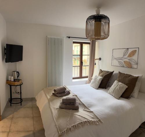 una camera da letto con un grande letto bianco con una finestra di L’auberge de Montsalier a Le Plan
