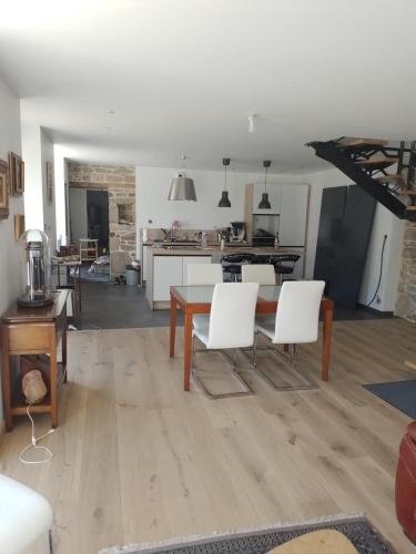 Il dispose d'une cuisine et d'un salon avec une table et des chaises blanches. dans l'établissement Meabel, à Bignan