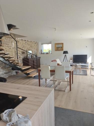 a living room with a staircase and a table and chairs at Meabel in Bignan