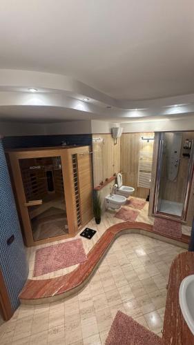 a large bathroom with two toilets and a sink at Via Sicilia in Cisterna di Latina