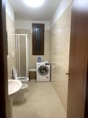 a bathroom with a washing machine and a washer at Casa Vacanze - Villa Claudia in Leporano Marina