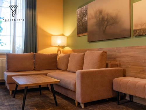 a living room with a couch and a table at MARIENSZTAT 8 Aparthotel in Warsaw