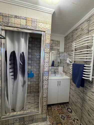 a bathroom with a shower curtain and a sink at House Beskyd in Skole