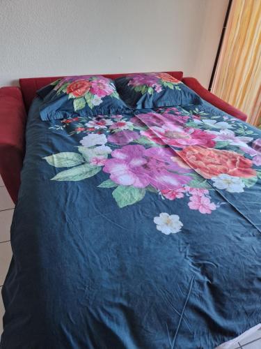 - un lit avec une couverture bleue et des fleurs dans l'établissement Appartement vue mer, à Perros-Guirec