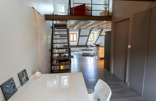 - un salon avec une table blanche et un escalier dans l'établissement Le Hippie-Chic, hyper centre, à Annecy